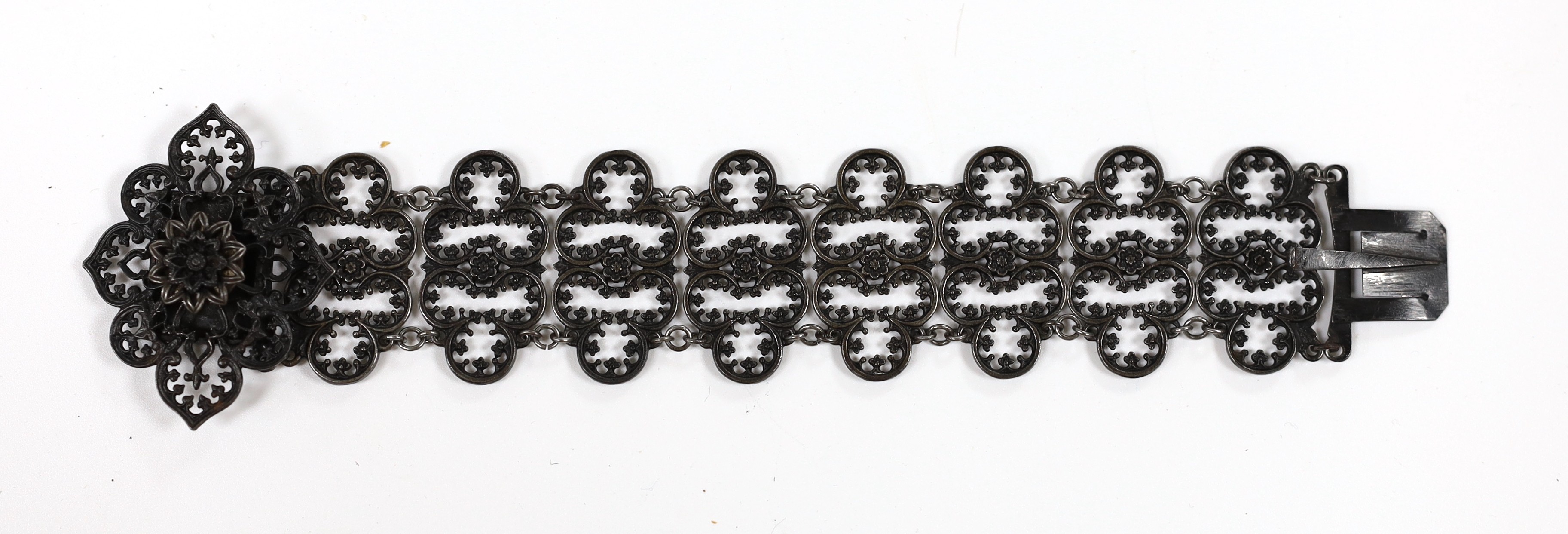 A 19th century Berlin iron work bracelet, with pierced cusped oval links and flower head clasp, stamped 'Geiss a Berlin', 17cm.